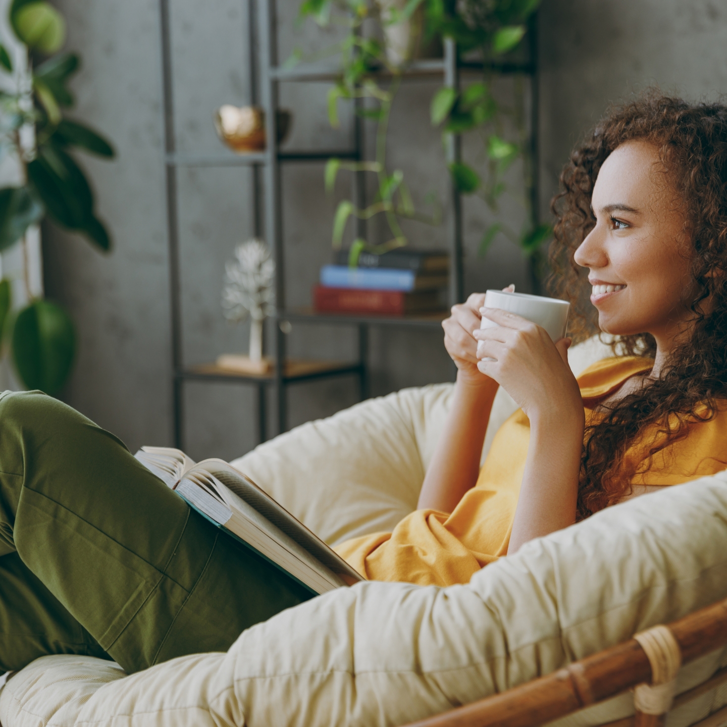 person sitting in a papasan chair with a hot beverage